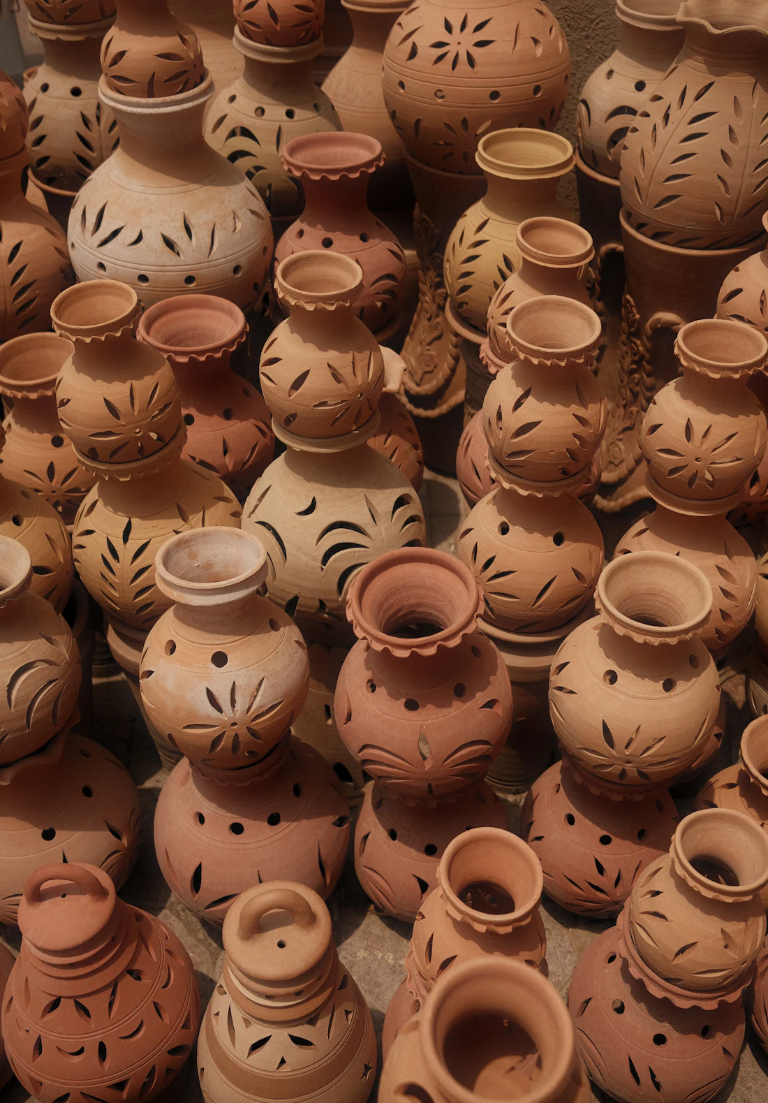 Pots en terre cuite ajourés alignés à l'atelier