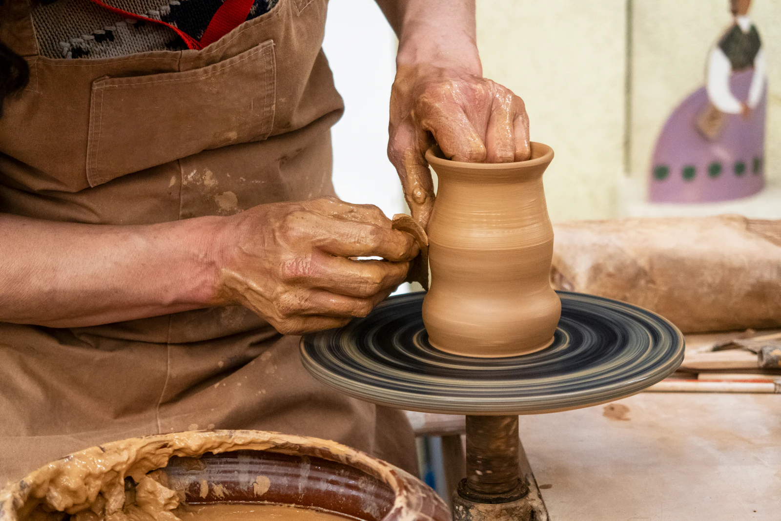 Mains façonnant un pot en terre sur un tour de potier