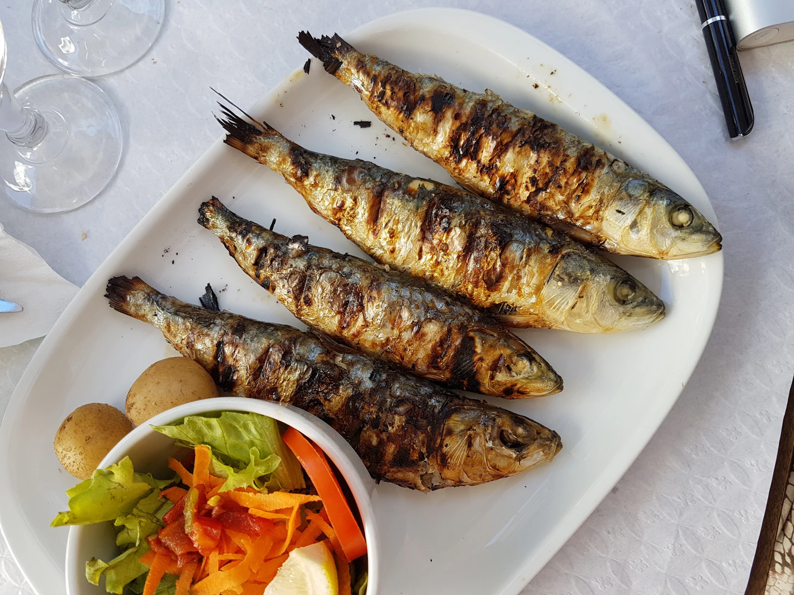 Sardines grillées servies avec des pommes de terre et une salade